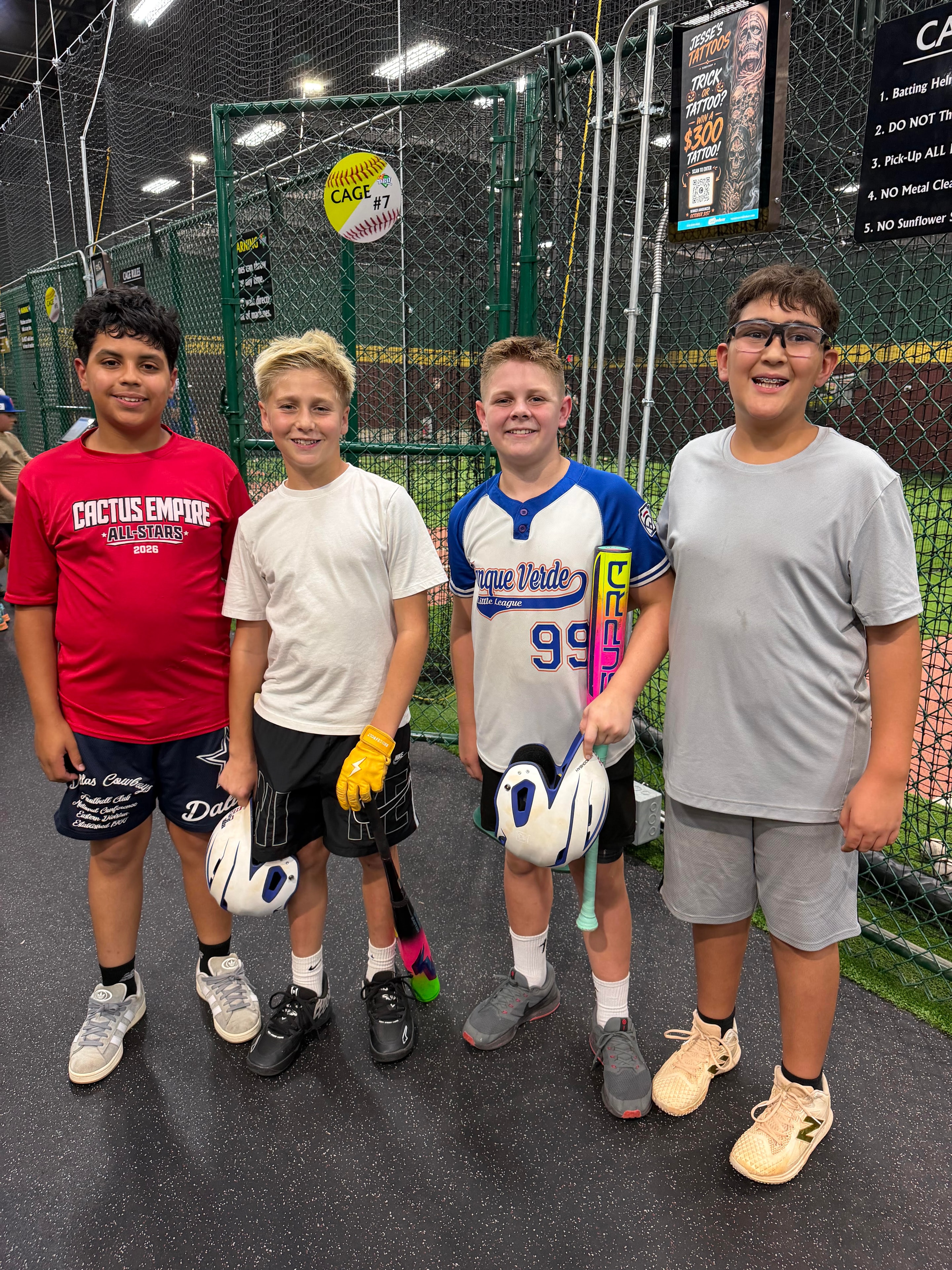 Four players at the batting cage facility