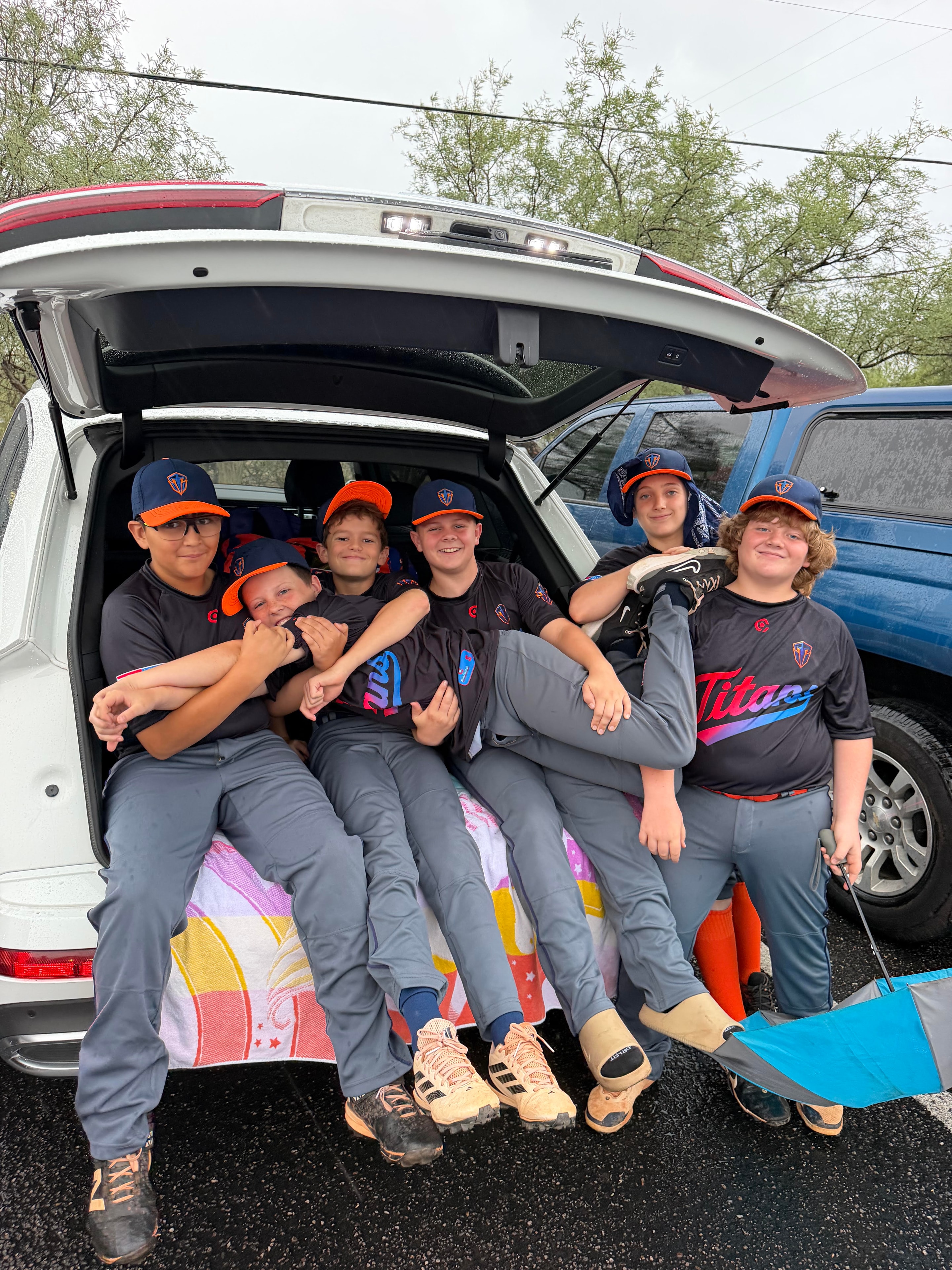 Titans players hanging out in the back of an SUV on a rainy day
